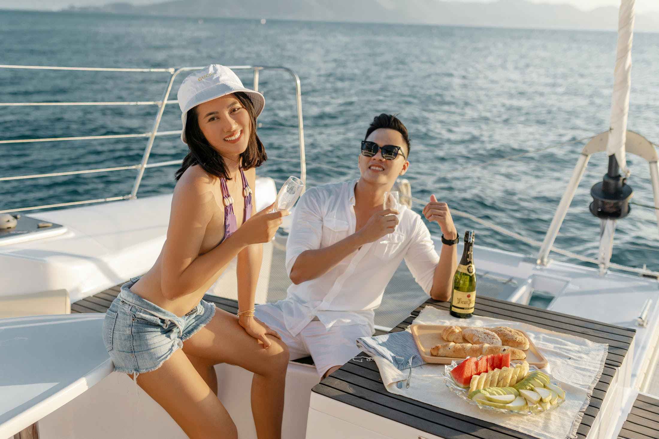 A young Asian couple enjoying a drink on a charter boat